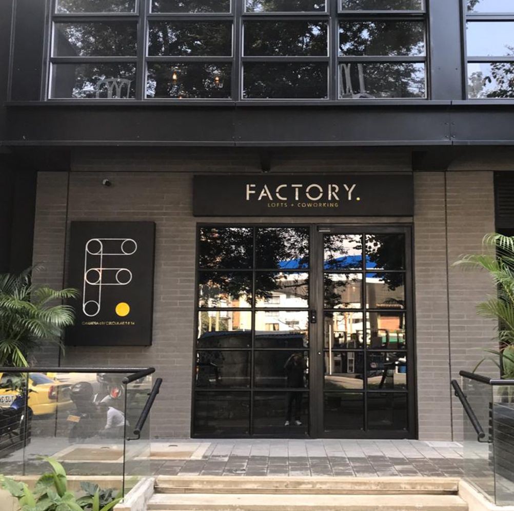 Entrance to a modern lofts and coworking space with glass doors and a logo sign.